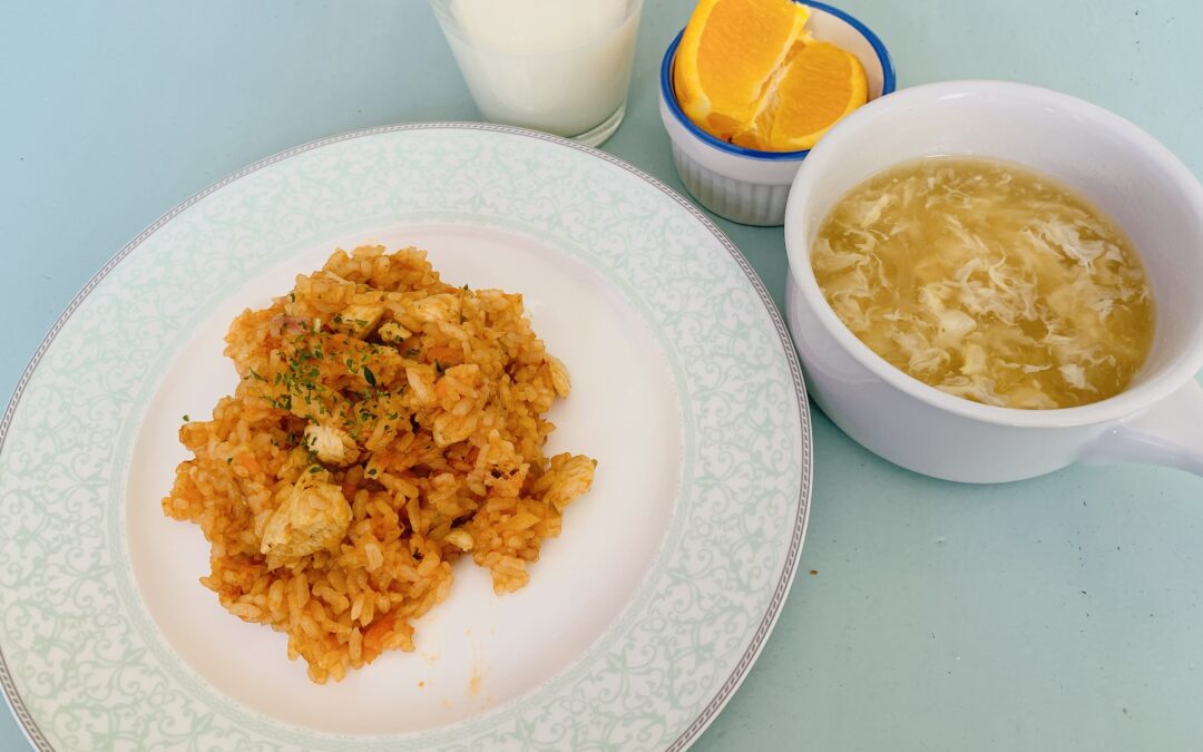 Tomato-chicken pilaf lunch with soup, orange slice, and milk